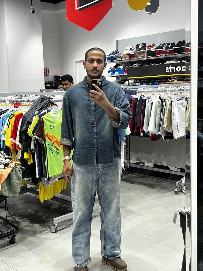 A mirror selfie taken inside a clothing store, standing among racks of sportswear and sneaker shelves — a photo the author attached to the post as an experiment, unrelated to the hiring topic.